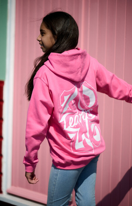 Junior female model showing back of hoodie by beach huts