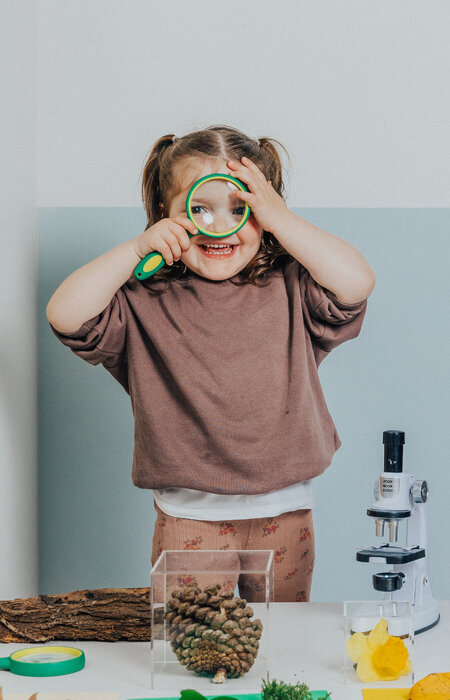 Girl smiling with magnifying glass
