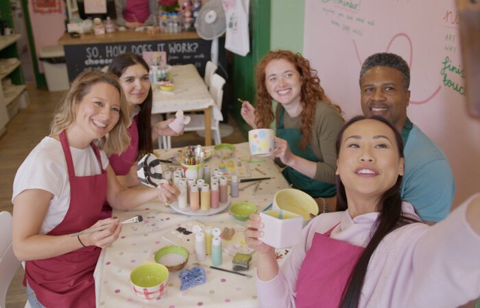Group of models doing pottery painting