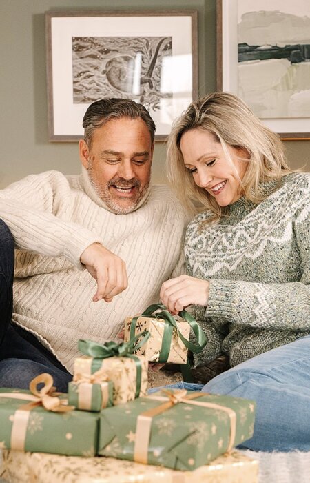 Model couple opening Christmas gifts together