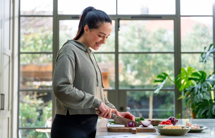 Model preparing dinner in kitchen