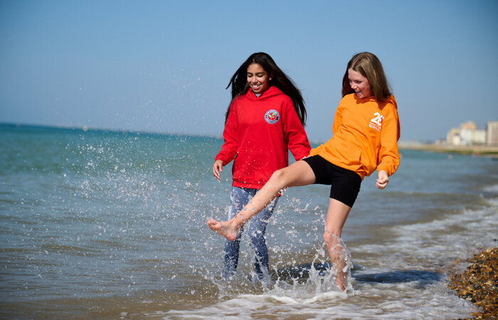 Two junior models playing by the sea
