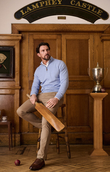 Classic model in smart attire sitting with cricket bat