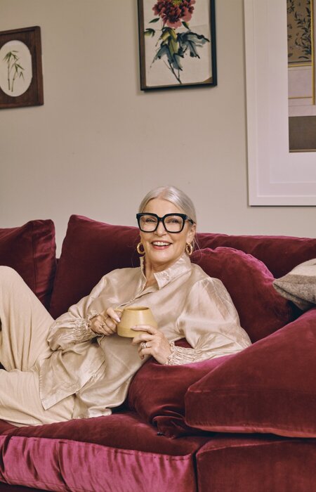 Lady wearing glasses with mug on sofa