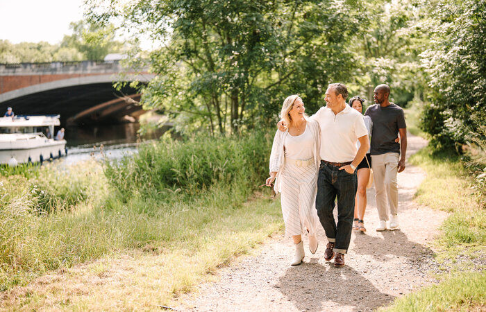 Classic model couples walking on riverbank