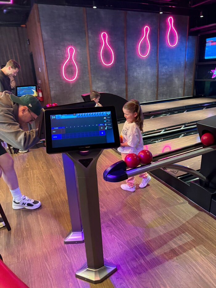 Behind the scenes shot of photographer with junior model at bowling lane