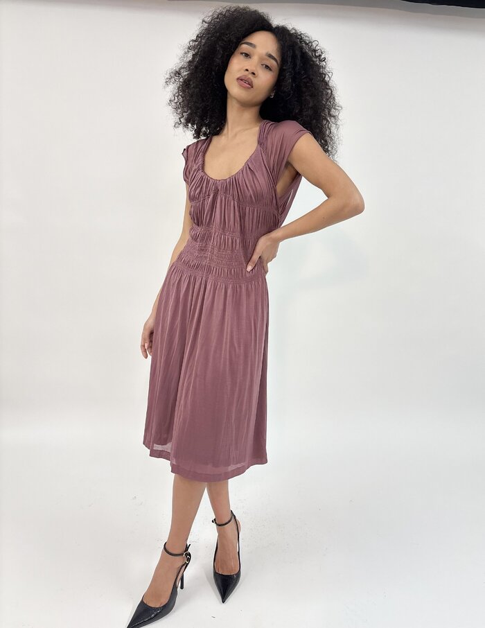 Female model in pink dress in studio