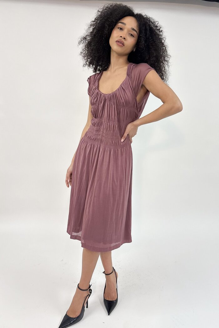 Female model in pink dress in studio