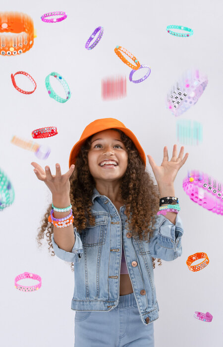 Junior model in denim with bracelets thrown into the air