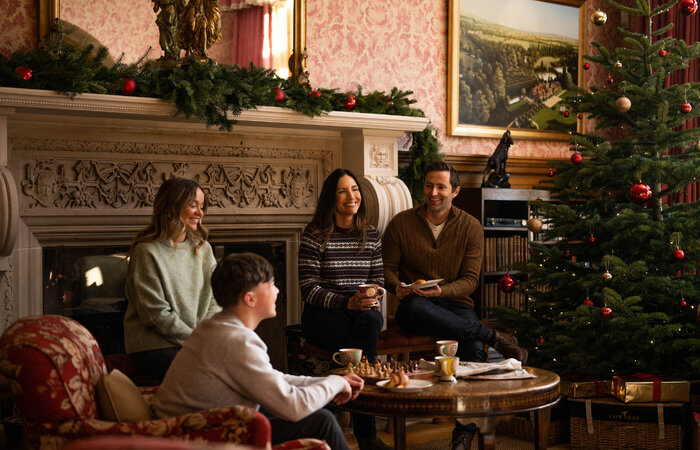 Model family sitting in front of fireplace