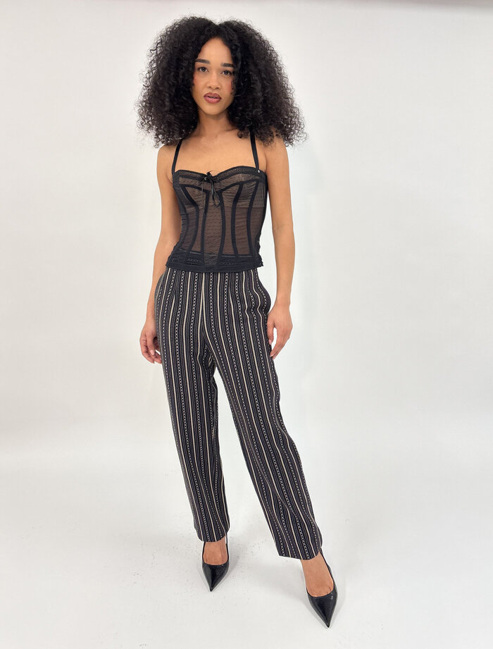 Female model in back corset top and trousers in studio
