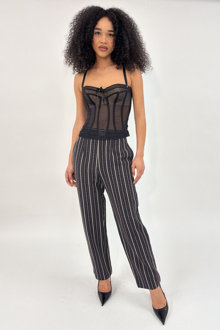 Female model in back corset top and trousers in studio