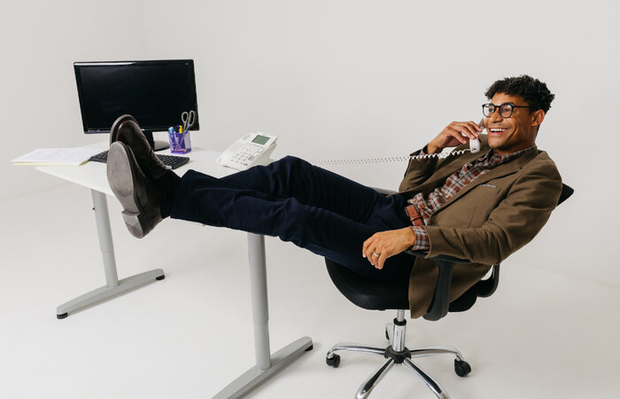 Male model sitting at desk on phone