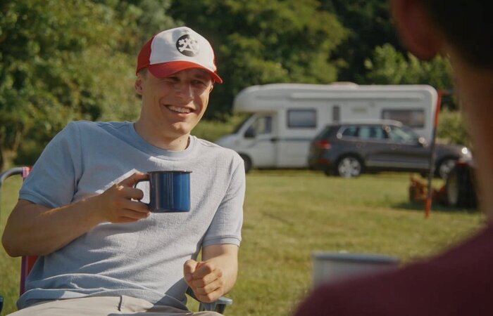 Male actor smiling and drinking tea
