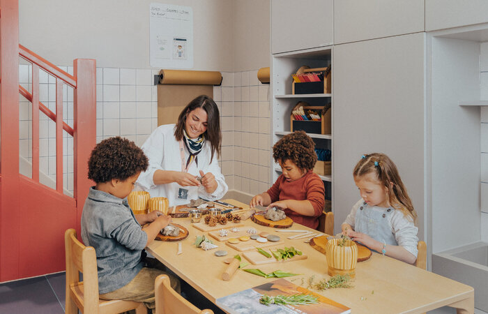 Children and teacher at table doing crafts