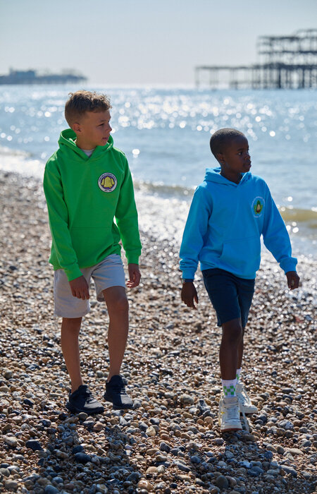 Junior models walking on beach in hoodies