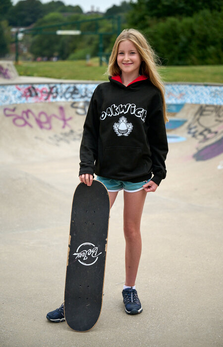 Junior model standing with skateboard