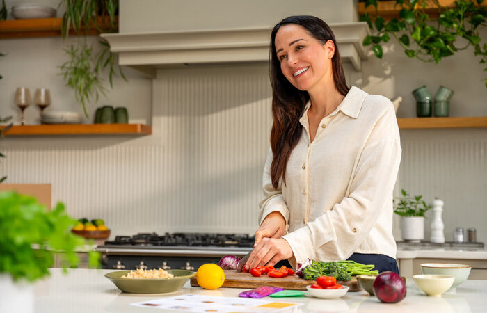 Model smiling and chopping vegetables