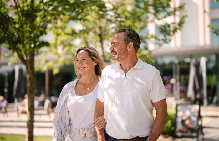 Classic model couple smiling walking in front of hotel