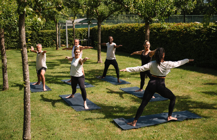 Group of classic models taking yoga class outdoors