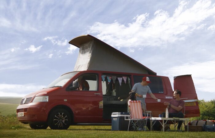 Three friends having tea by a van