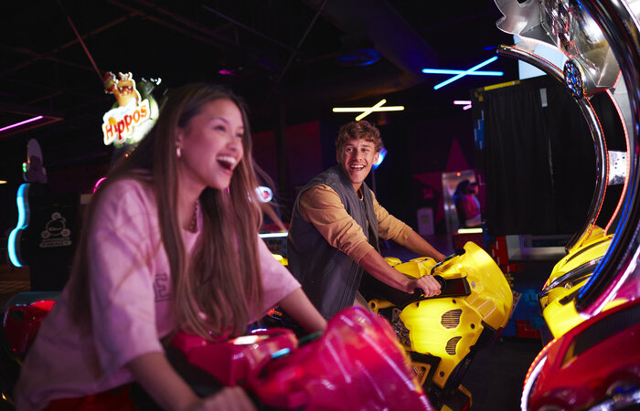 Models laughing in arcade together