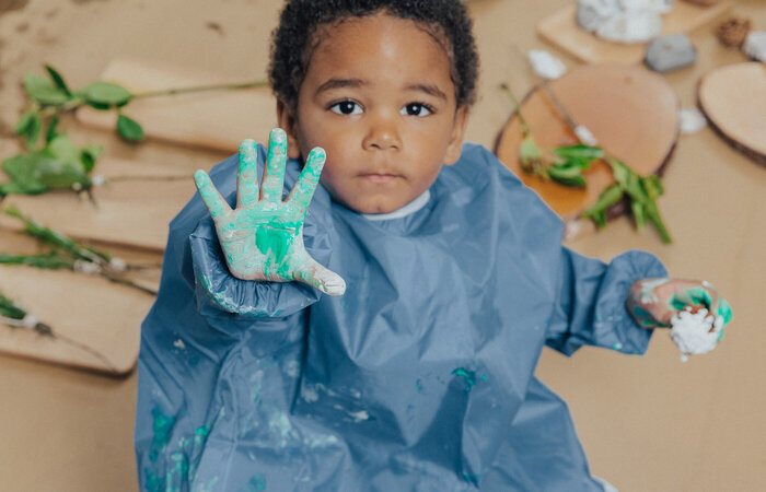 Child with painted hand stretched out
