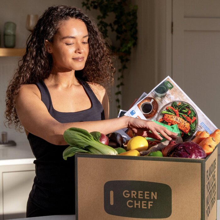 Female model unpacking box of fresh vegetables