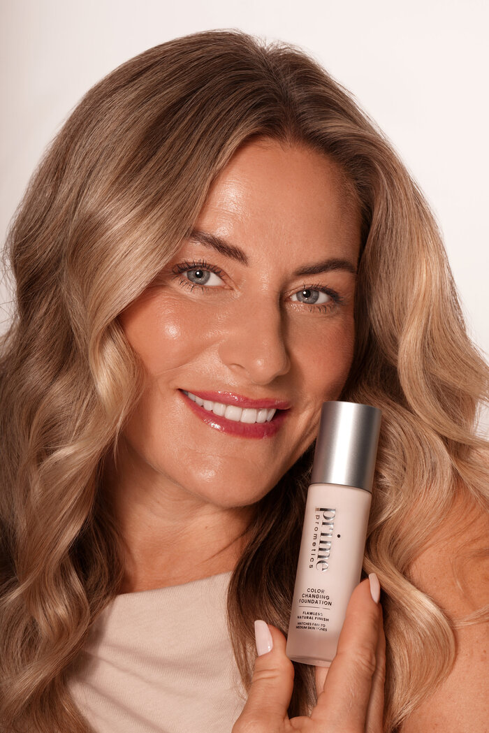Model holding beauty product smiling