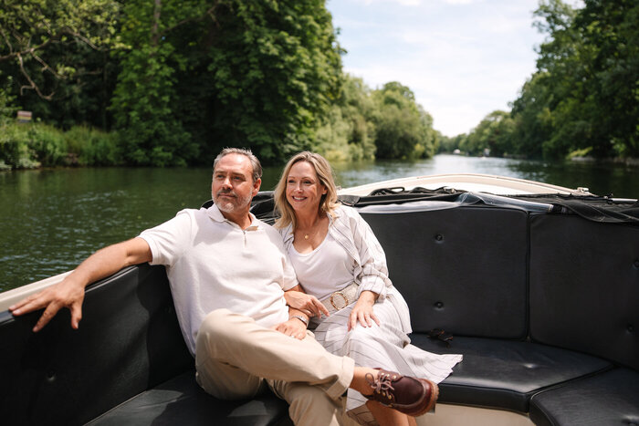 Classic model couple enjoying boat trip on the river