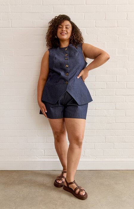 Female model in denim waistcoat top and shorts