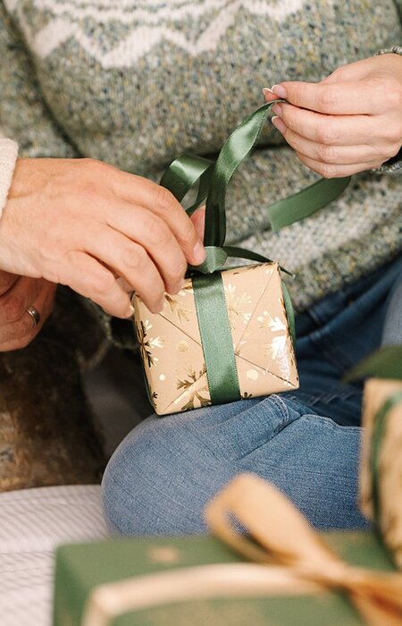 Close up of hands opening ribbon on gifts