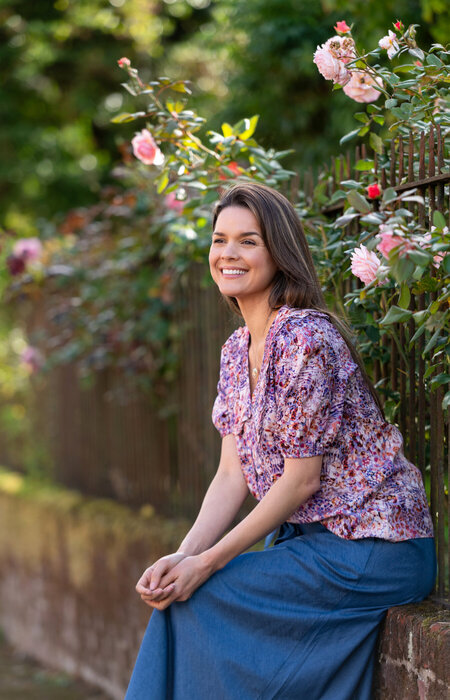Model sitting on wall smiling