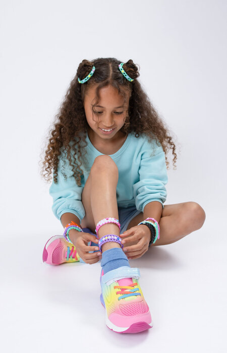 Junior model sat on floor with jelly bands on ankle