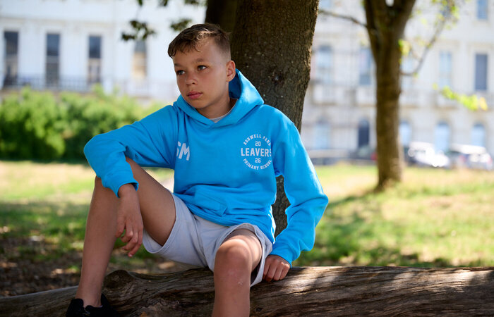 Junior model sitting on a tree stump