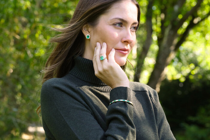 Female model wearing ring and smiling