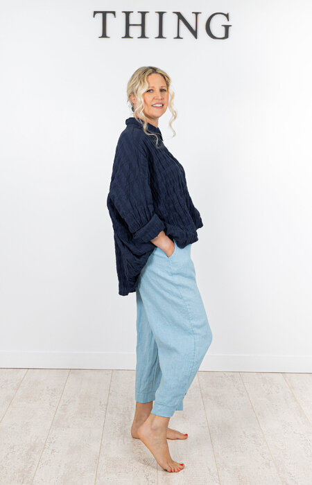 Model in shirt and jeans bare feet in studio
