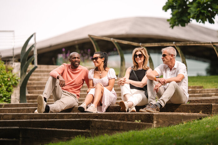 Two couples sat on steps happy chatting