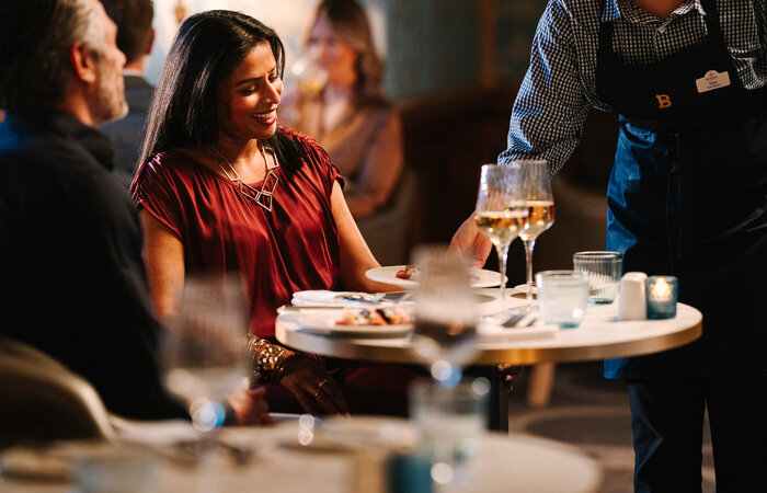 Model being served wine at the table