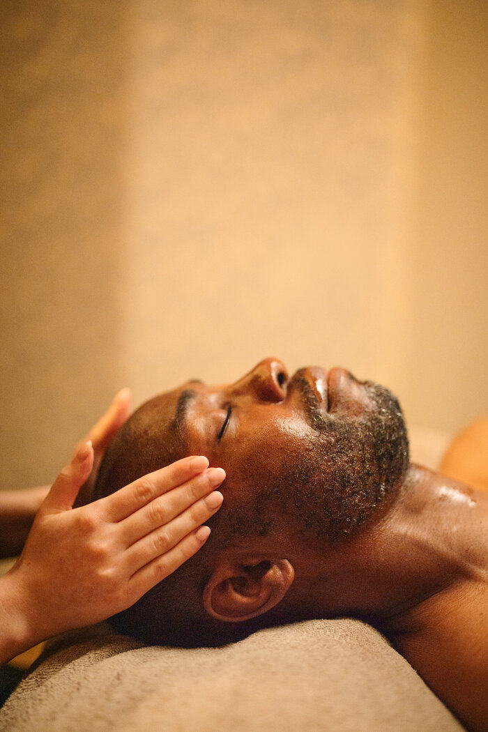 Male model eyes closed having facial at spa