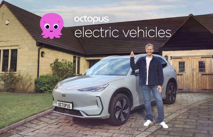 Male actor in front of car on drive smiling with car key