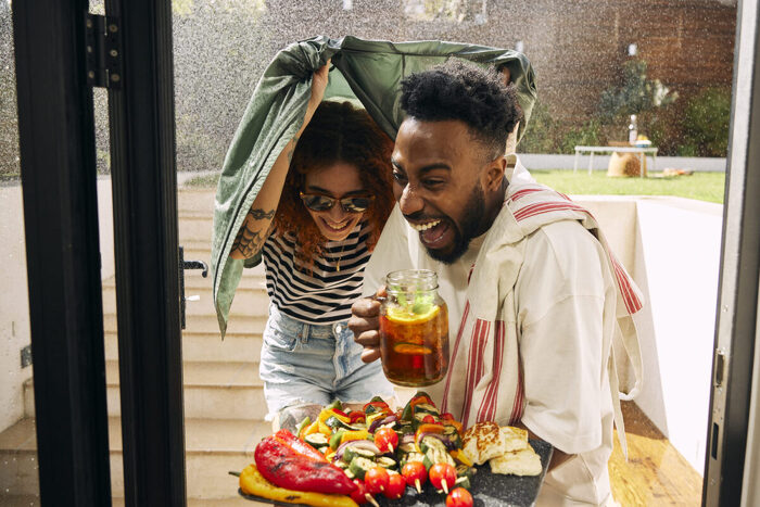 model couple laughing holding food in rain