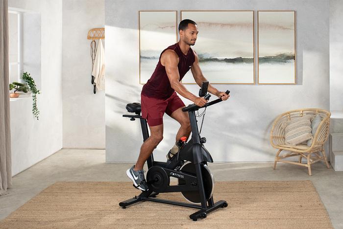 Male fitness model on exercise bike