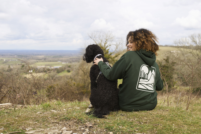 Female model with dog sitting on grass