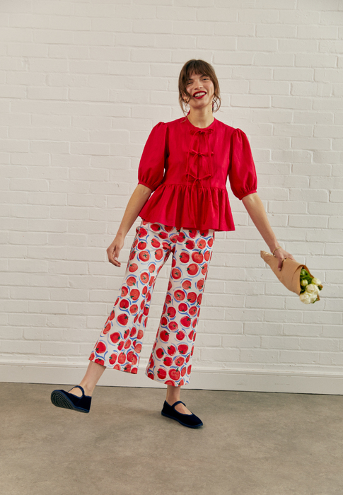 Female model laughing and kicking out leg holding flowers