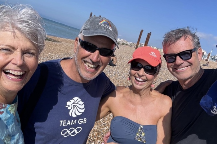 Four classic models laughing together at Brighton beach