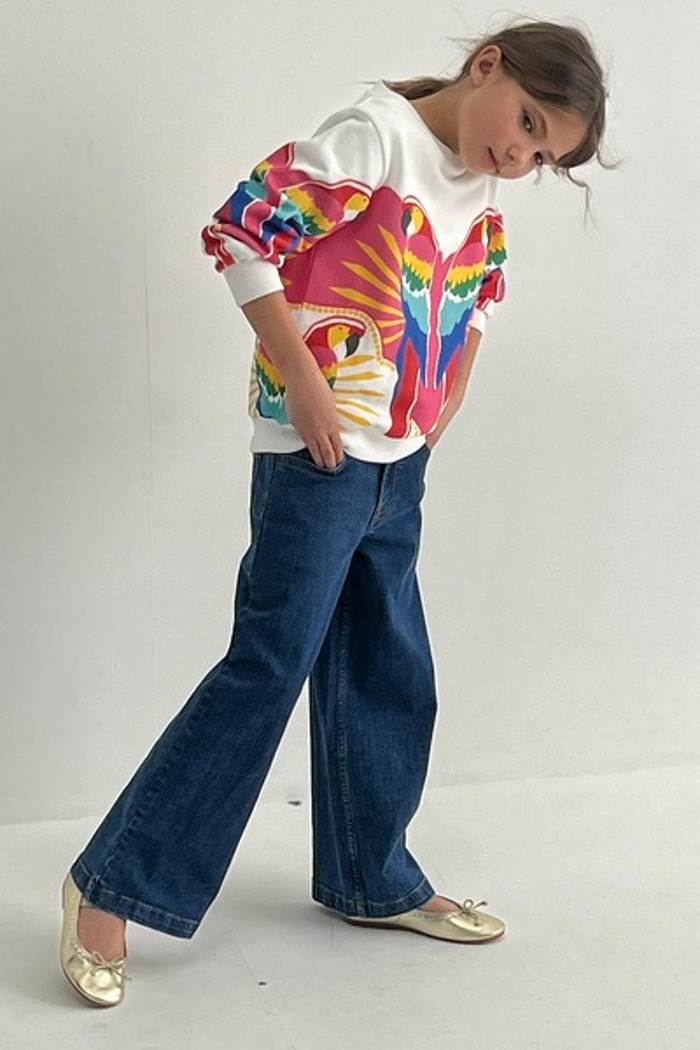 Junior model standing in jeans and top