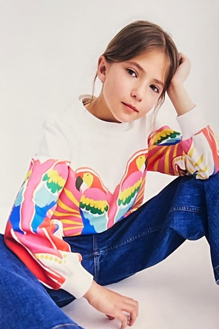 Junior model in jeans and top sitting down looking cool