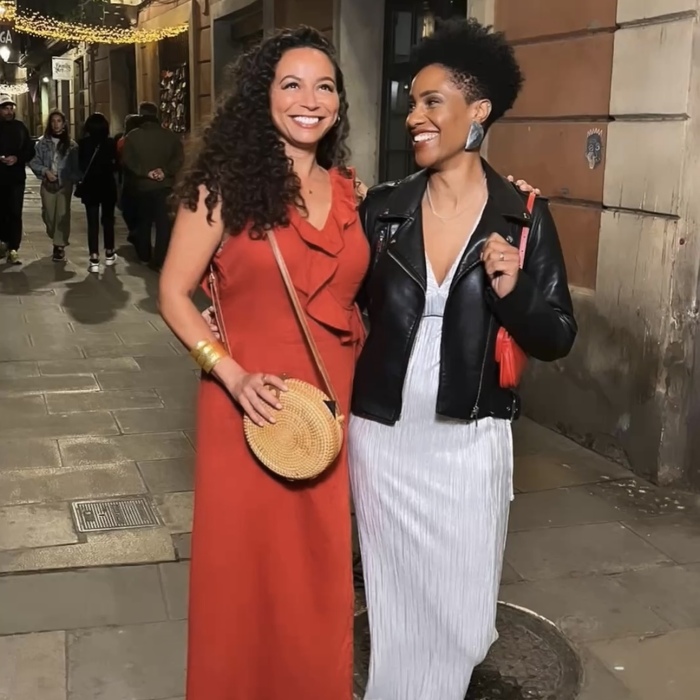 Two female models walking and smiling in the street