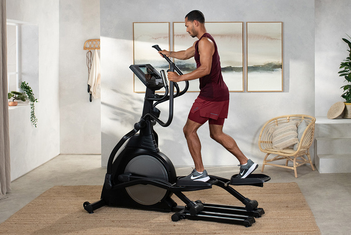 Male fitness model on cross trainer